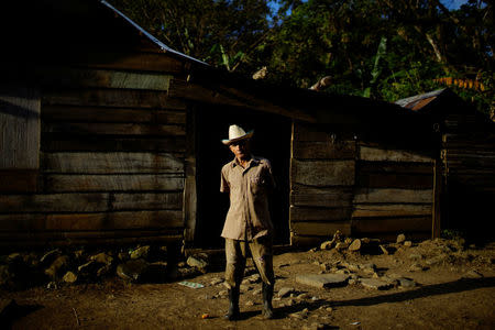 Farmer Luca Castillo, 84, poses for a photograph in front of his home in the village of Santo Domingo, in the Sierra Maestra, Cuba, March 30, 2018. REUTERS/Alexandre Meneghini