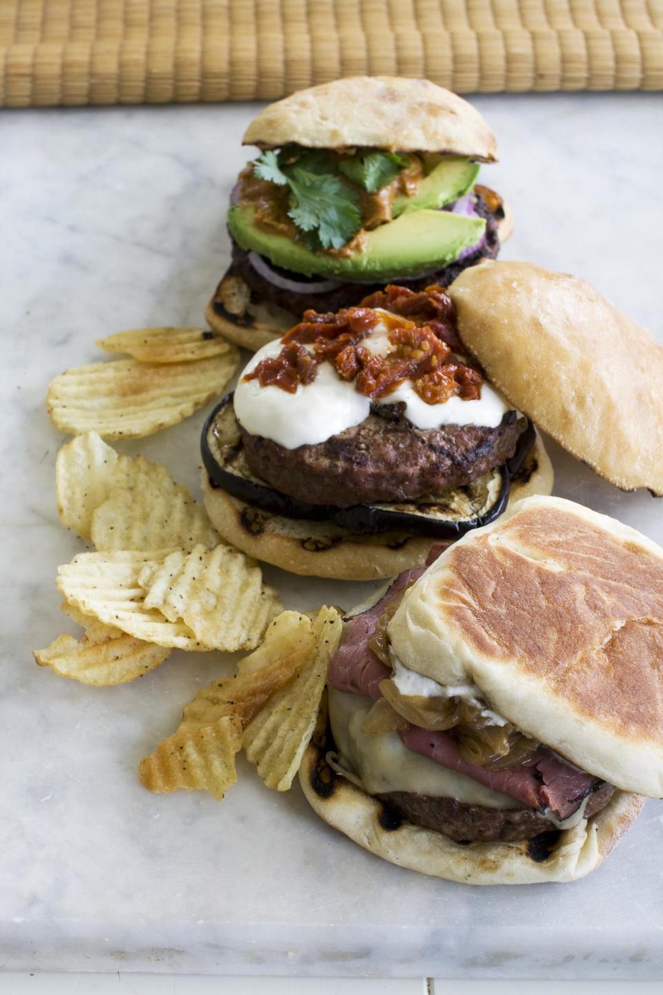 In this image taken on June 10, 2013, from front to rear, The New Yorker, The Eggplant Parm and The Thai, burgers are shown in Concord, N.H. (AP Photo/Matthew Mead)