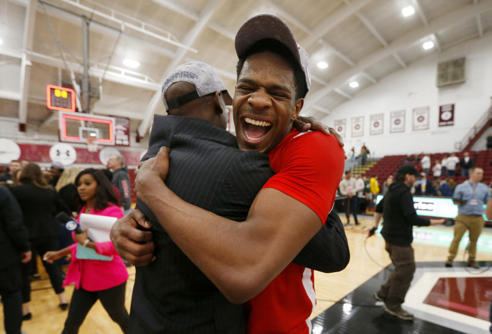 Boston University's Walter Whyte celebrates with head coach Joe Jones after winning the NCAA Patriot League Conference basketball championship over Colgate at Cotterell Court, Wednesday, March 11, 2020, in Hamilton, N.Y. (AP Photo/John Munson)