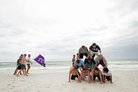 Students try to make a pyramid during spring break festivities in Panama City Beach, Florida March 13, 2015. REUTERS/Michael Spooneybarger