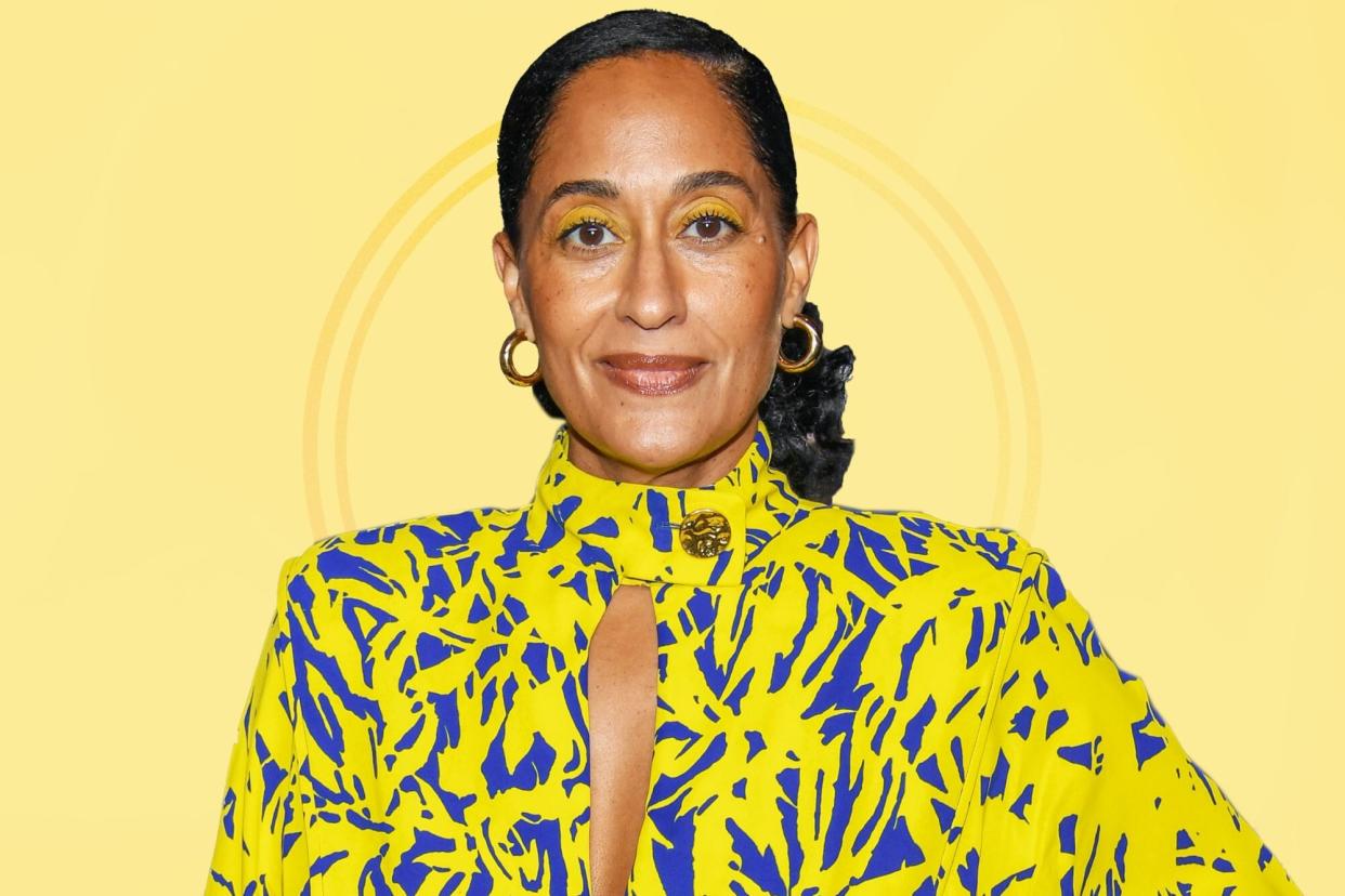 Tracee Ellis Ross wearing a yellow and blue patterned dress against a yellow background