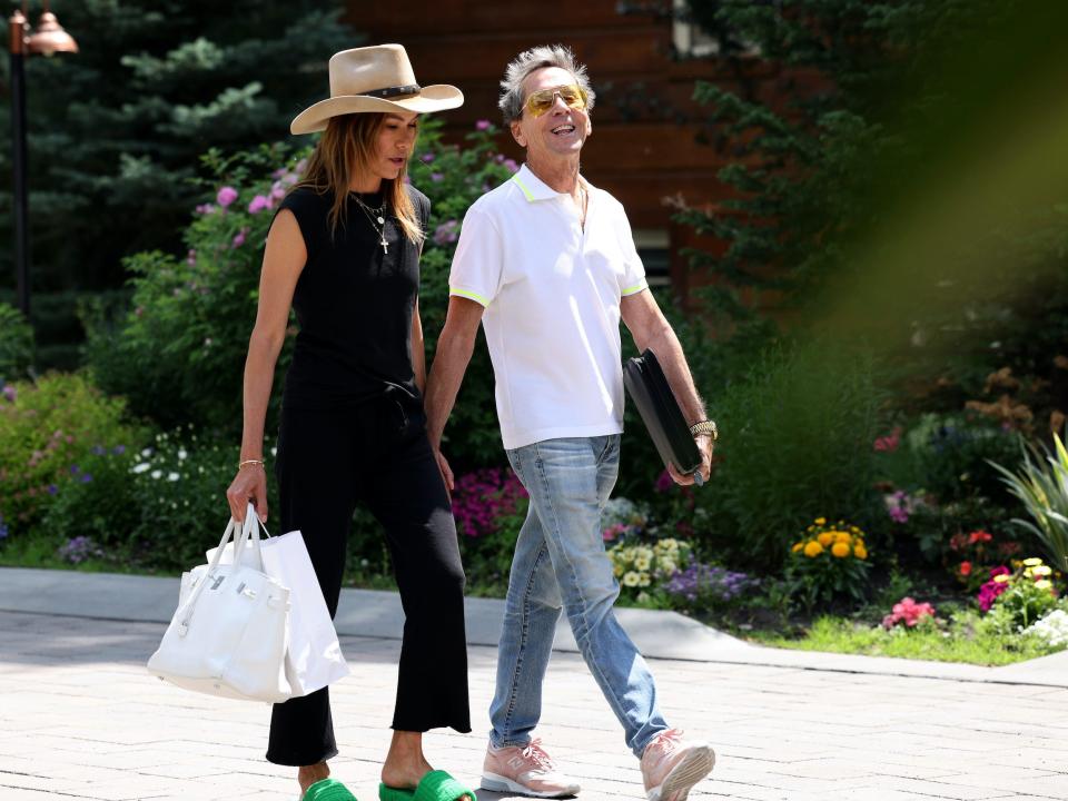 Brian Grazer walks smiling with Veronica Smiley at Sun Valley