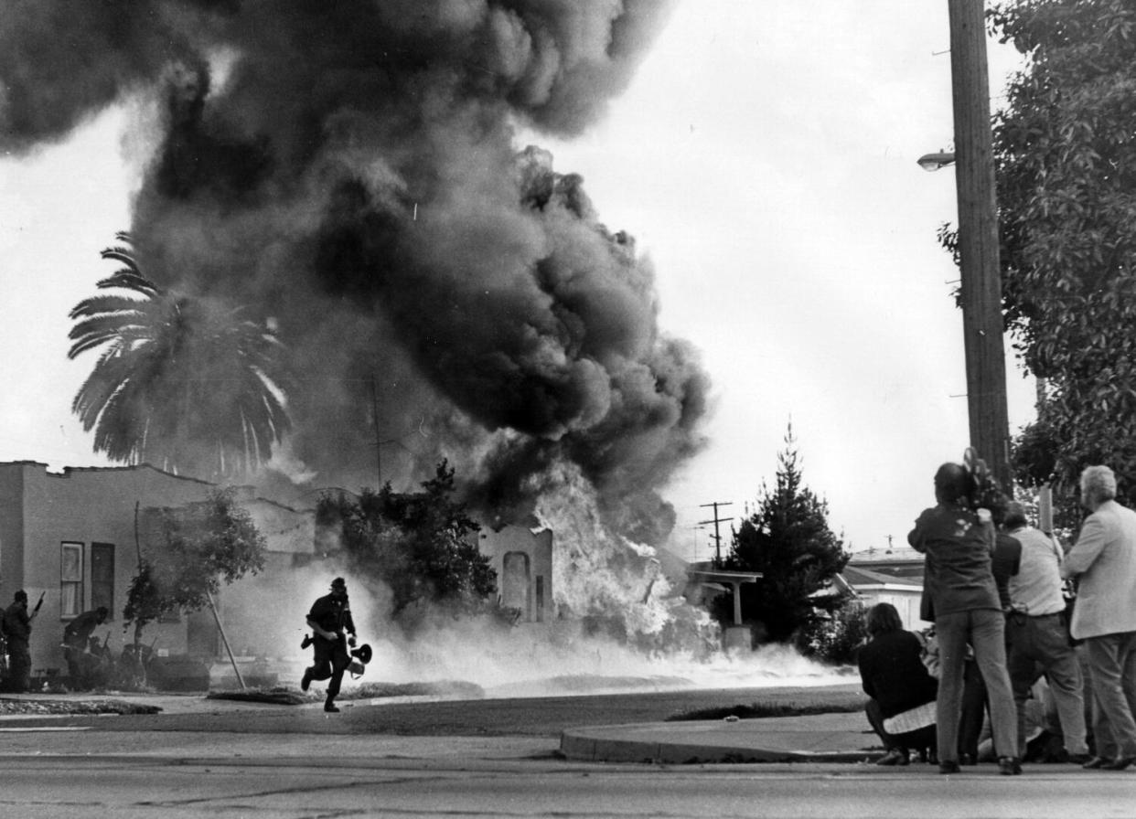 Thick, dark smoke rises from a house