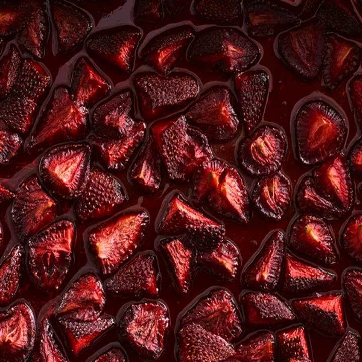 dark red slow roasted strawberries on baking sheet
