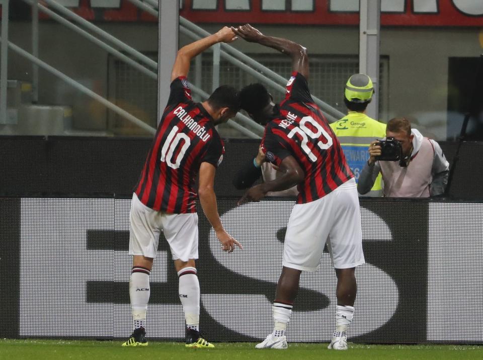 AC Milan's Franck Kessie, right, celebrates with teammate Hakan Calhanoglu after scoring his side's opening goal during the Serie A soccer match between AC Milan and Roma at the Milan San Siro Stadium, Italy, Friday, Aug. 31, 2018. (AP Photo/Antonio Calanni)
