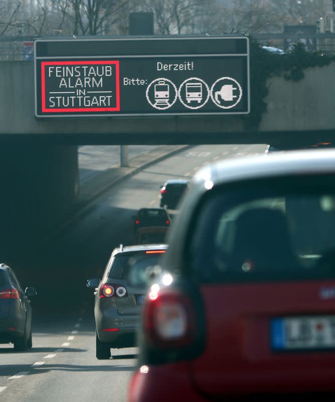 FILE PHOTO: Cars pass a sign alerting about fine particulates on a busy street in downtown Stuttgart