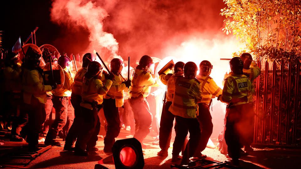 Police officers battle with flares let off by Legia fans ahead of the game at Villa Park. - Paul Childs/Action Images/Reuters