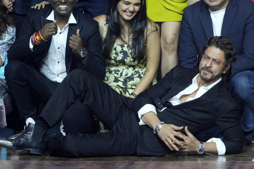 FILE - Bollywood superstar Shah Rukh Khan lies on the floor as he posses with others during a press conference after success of their movie 'Jawan' in Mumbai, India, on Sept. 15, 2023. India’s Hindi language movie industry, Bollywood, made an impressive financial recovery in 2023 after a pandemic-driven slowdown, audience fatigue with big studio productions and Bollywood megastars, and streaming platforms taking away a big chunk of viewership. (AP Photo/Rajanish Kakade, File)