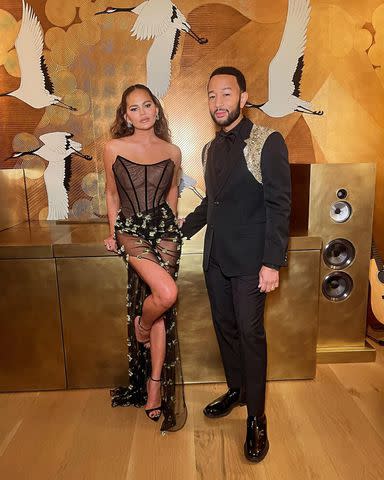 Chrissy Teigen puts on a leggy display with a high slit skirt that reveals  her Spanx