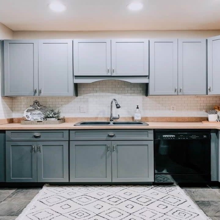 A reviewer photo showcasing the peel-and-stick tiles in white on the backsplash in the kitchen