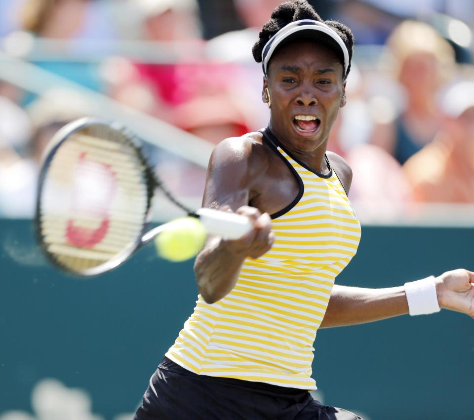 Venus Williams returns to Eugenie Bouchard, of Canada, during the Family Circle Cup tennis tournament in Charleston, S.C., Thursday, April 3, 2014. (AP Photo/Mic Smith)