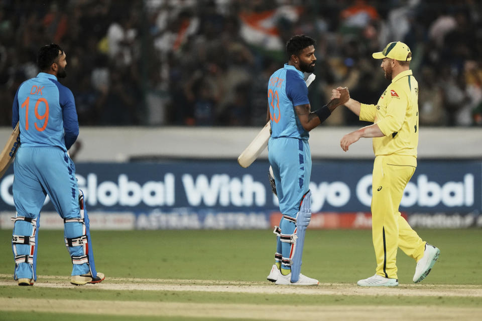 Australia's captain Aaron Finch, right, congratulates India's Hardik Pandya, center, on their win in the third T20 cricket match between India and Australia, in Hyderabad, India, Sunday, Sept. 25, 2022. (AP Photo/Mahesh Kumar A)