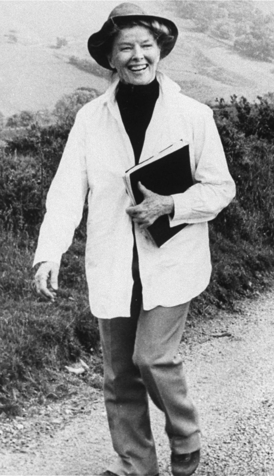 FILE - Actress Katharine Hepburn strolls down a country lane on location near London during the filming of their made for TV movie, "The Corn Is Green," in this Jan. 23, 1979 file photo. "The fact that she wore slacks and wanted to be comfortable influenced women's ready-to-wear in the United States," said Jean Druesedow, director of the Kent State University Museum, which was given 700 items from Hepburn’s estate. (AP Photo/File)