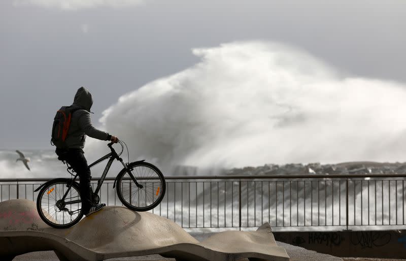 A man looks at waves during the storm "Gloria" on Barceloneta beach, in Barcelona