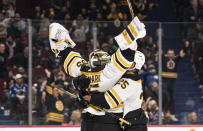 Boston Bruins goalie Linus Ullmark, left, celebrates his empty-net goal against the Vancouver Canucks with Brandon Carlo during the third period of an NHL hockey game in Vancouver, British Columbia, Saturday, Feb. 25, 2023. (Rich Lam/The Canadian Press via AP)