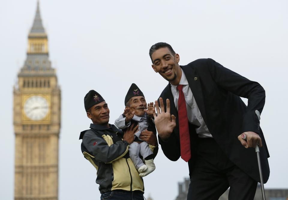 The world's shortest man Chandra Bahadur Dangi is held by nephew Dolakh Dangi as they pose with the tallest living man Sultan Kosen to mark the Guinness World Records Day in London