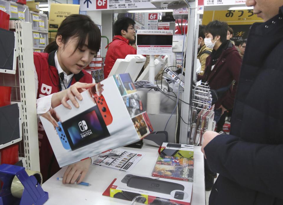 An employee of electronics retailer Bic Camera sells Nintendo's newest computer game "Switch" in central Tokyo, Friday, March 3, 2017. (AP Photo/Koji Sasahara)