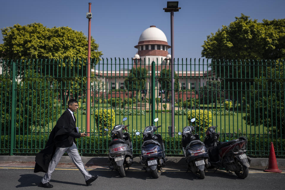A lawyer walks briskly inside the Supreme Court premises ahead of a verdict on Hijab ban, in New Delhi, India, Thursday, Oct. 13, 2022. Two judges of India's top court on Thursday differed on a ban on the wearing of the Muslim headscarf ''Hijab'' in educational institutions in southern Karnataka state and referred the issue to a larger bench of three or more judges to settle the issue. (AP Photo/Altaf Qadri)