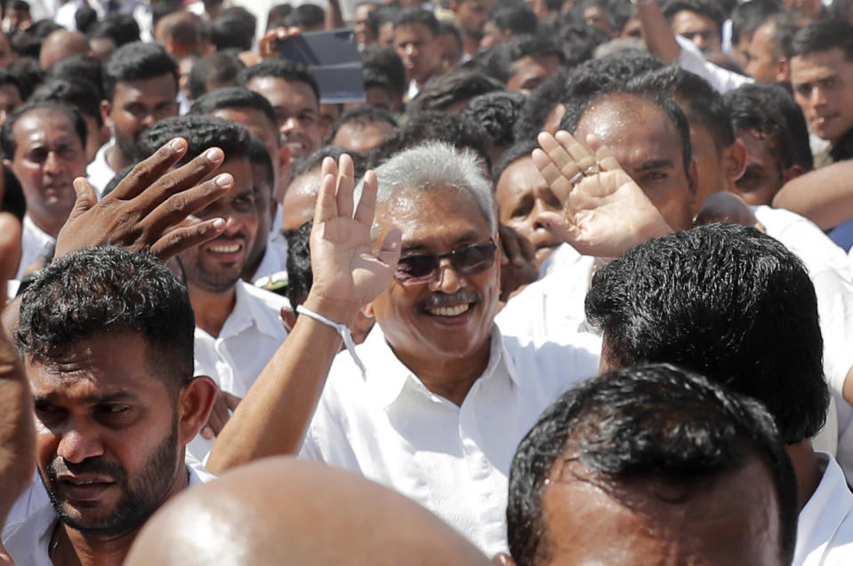 Sri Lanka's newly elected president Gotabaya Rajapaksa greets people as he leaves after taking the oath of office during the swearing in ceremony held at the 140 B.C Ruwanweli Seya Buddhist temple in ancient kingdom of Anuradhapura in northcentral Sri Lanka Monday, Nov. 18, 2019. The former defense official credited with ending a long civil war was Monday sworn in as Sri Lanka’s seventh president after comfortably winning last Saturday’s presidential election. (AP Photo/Eranga Jayawardena)