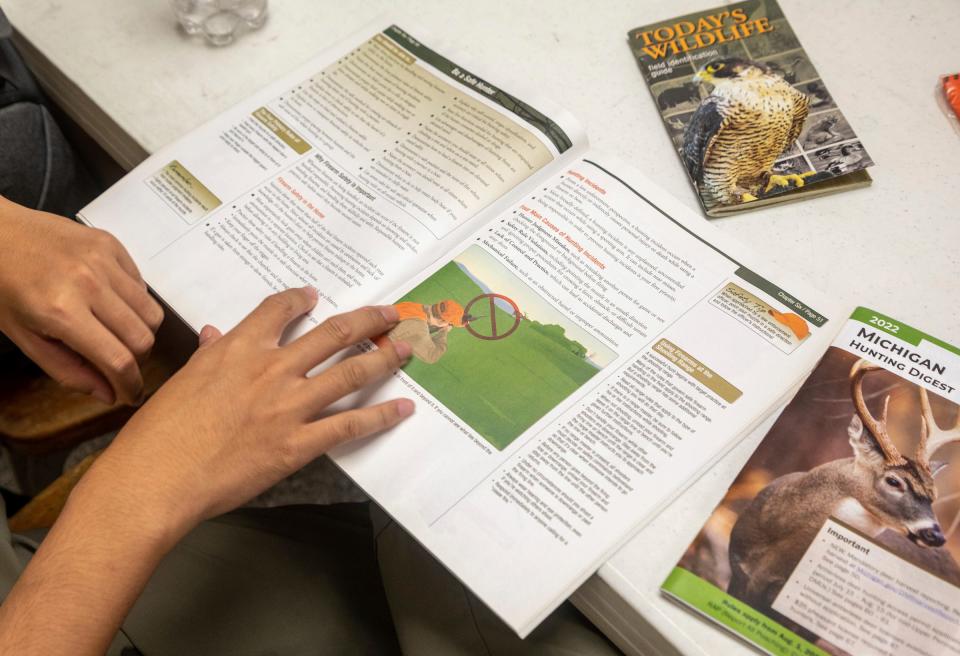 A student looks through a hunting booklet during the Hunter Safety Field Day at the Washtenaw Sportsman's Club in Ypsilanti on Saturday, Sept. 9, 2023.