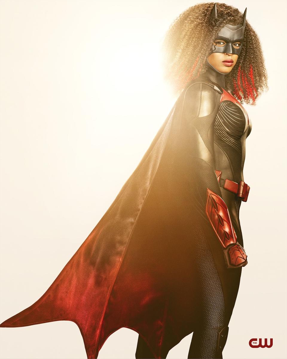 A woman in a black bodysuit, mask and cape.