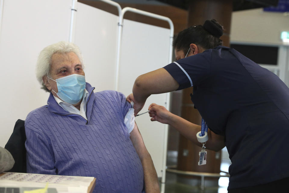 British entertainer Lionel Blair, 92, receives the Pfizer BioNtech COVID-19 vaccine at a NHS vaccine centre set up in the grounds of the horse racing course at Epsom, England, Wednesday Dec. 16, 2020. (Steve Parsons/Pool via AP)