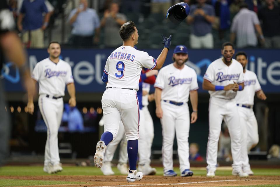 Texas Rangers' Mark Mathias (9) tosses his helmet as he approaches the plate after hitting a game-ending home run in the ninth inning of the team's 8-7 win in a baseball game against the Oakland Athletics in Arlington, Texas, Tuesday, Sept. 13, 2022. (AP Photo/Tony Gutierrez)