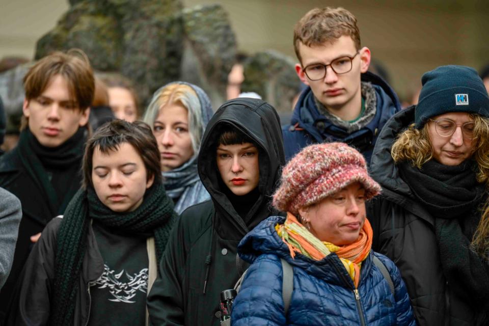 Mourners stand outside the headquarters of Charles University after the mass shooting (AP)