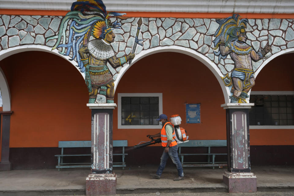 A health worker sanitizes outside Town Hall on the second day of a four-day lockdown, decreed by local authorities to help curb the spread of COVID-19 in the Kaqchikel Indigenous town of San Martin Jilotepeque, Guatemala, Friday, July 9, 2021. On Thursday, Guatemala announced its highest number of infections since the pandemic began, with 3,000 infected in a single day. (AP Photo/Moises Castillo)