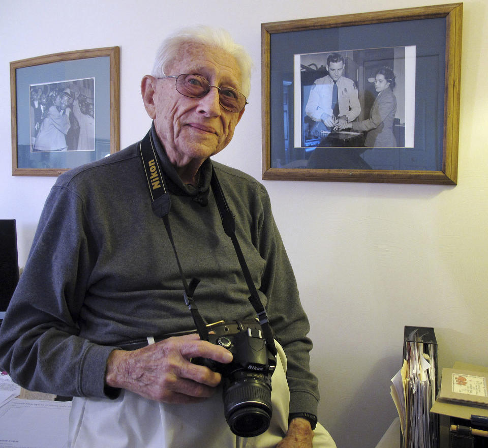 FILE - Former Associated Press photographer Gene Herrick poses between two of his most famous pictures at his home in Rocky Mount, Va., on Feb. 2, 2018. Herrick, a retired Associated Press photographer who covered the Korean War and is known for his iconic images of Martin Luther King Jr., Rosa Parks and the trial of the killers of Emmett Till in the early years of the Civil Rights Movement, died Friday, April 12, 2024. He was 97. (AP Photo/Allen G. Breed, file)