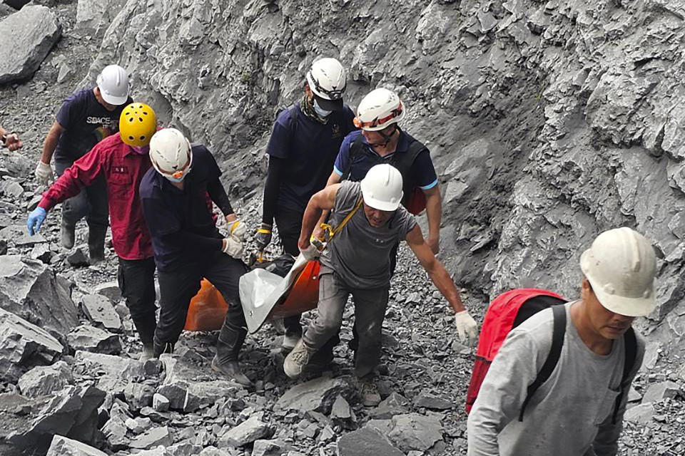 In this photo released by the Hualien Fire Department, firefighters and quarry workers evacuate a body from the Ho Ren Quarry a day after a powerful earthquake struck in Hualien County, eastern Taiwan, Thursday, April 4, 2024. Rescuers are searching for people out of contact a day after Taiwan's strongest earthquake in a quarter century damaged buildings, caused multiple rockslides and killed several people. (Hualien Fire Department via AP)