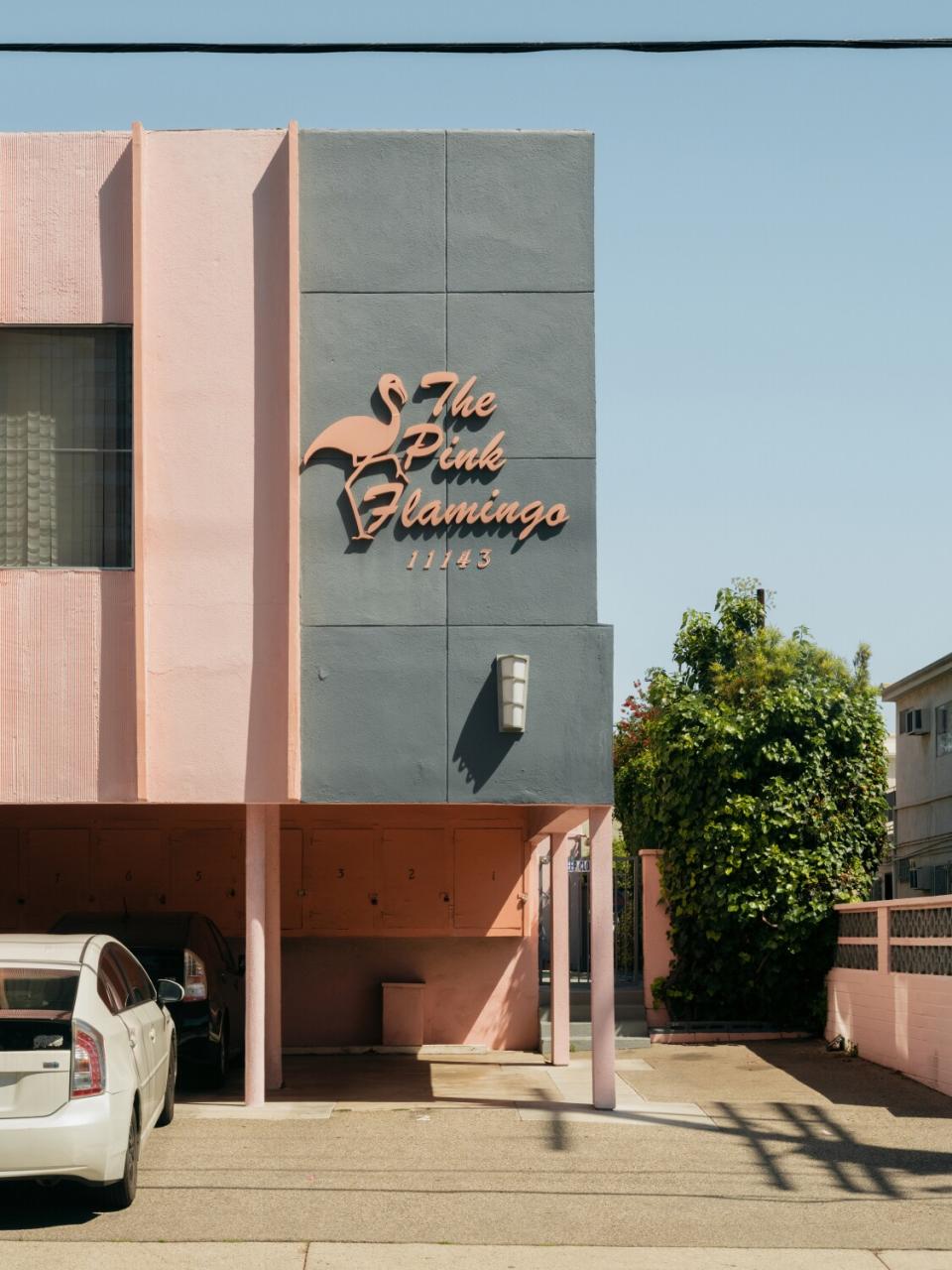 Apartment building sign that reads "The Pink Flamingo 11143"