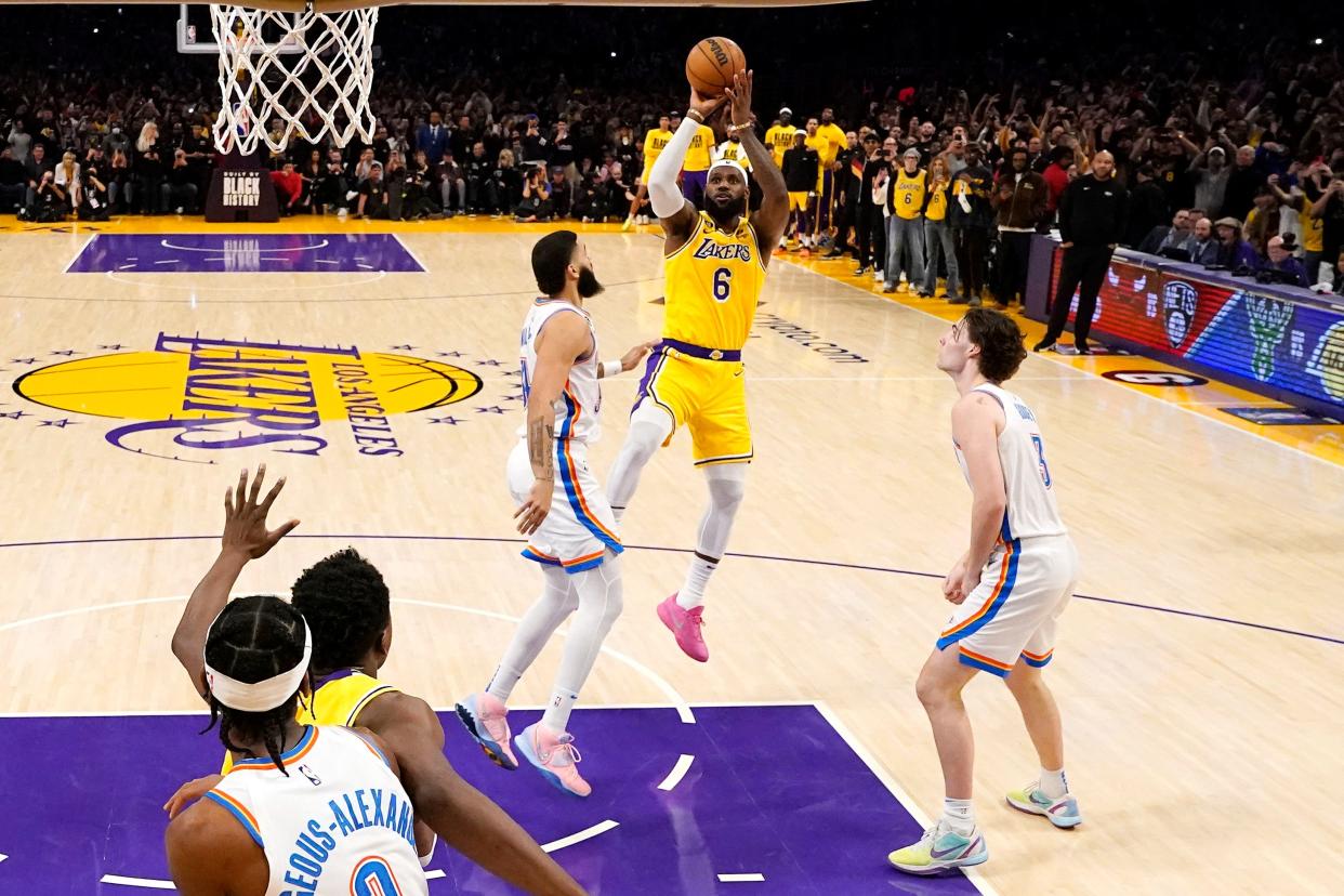 Los Angeles Lakers forward LeBron James (6) scores to pass Kareem Abdul-Jabbar to become the NBA's all-time leading scorer as Oklahoma City Thunder guard Josh Giddey (3) and forward Kenrich Williams defend during the second half of an NBA basketball game Tuesday, Feb. 7, 2023, in Los Angeles.(AP Photo/Ashley Landis)