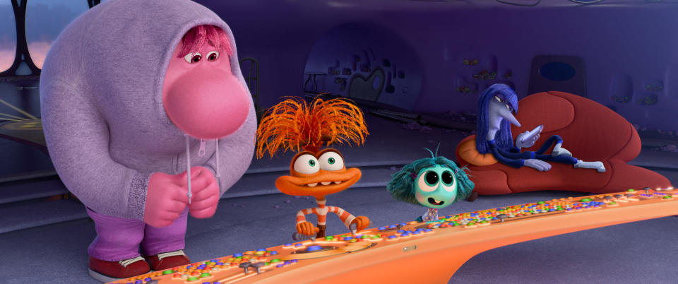 Embarrassment (voice of Paul Walter Hauser), Anxiety (voice of Maya Hawke), Envy (voice of Ayo Edebiri) and Ennui (voice of Adèle Exarchopoulos) are ready to take a turn at the console in Inside Out 2. (Pixar/Disney)