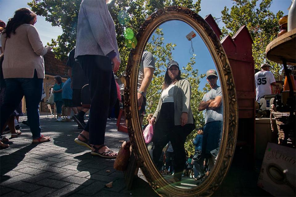 (10/1/17) A mirror for sale reflects the bargain hunters at the Lodi Street Faire on Church School Street in downtown Lodi. CLIFFORD OTO/THE STOCKTON RECORD