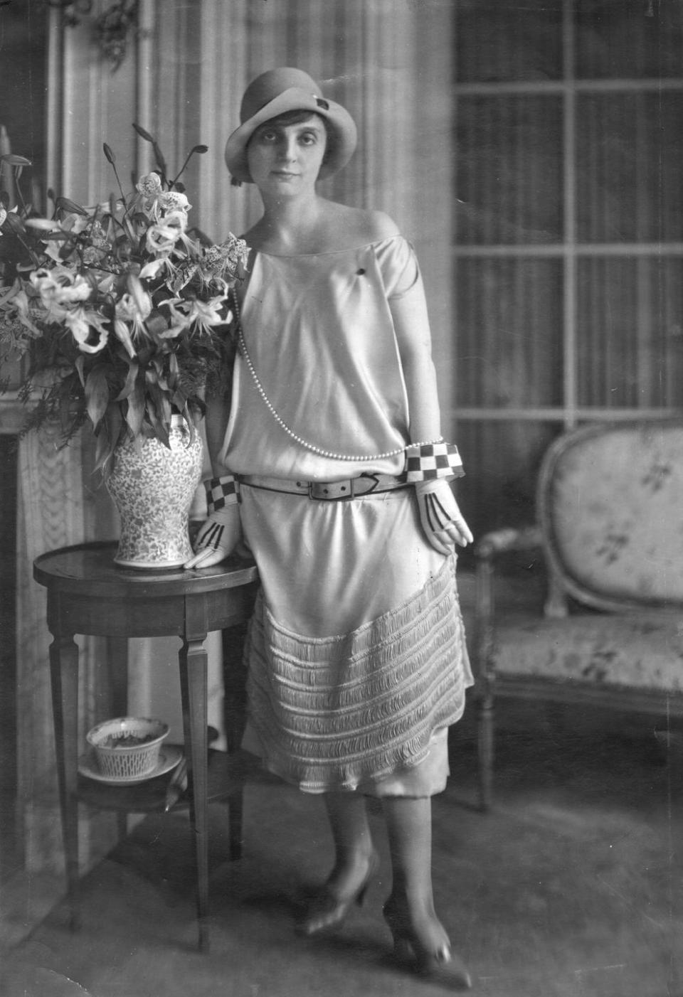 <p>Anna Elisabeth, a French poet and novelist, poses next to a large flower arrangement.</p>