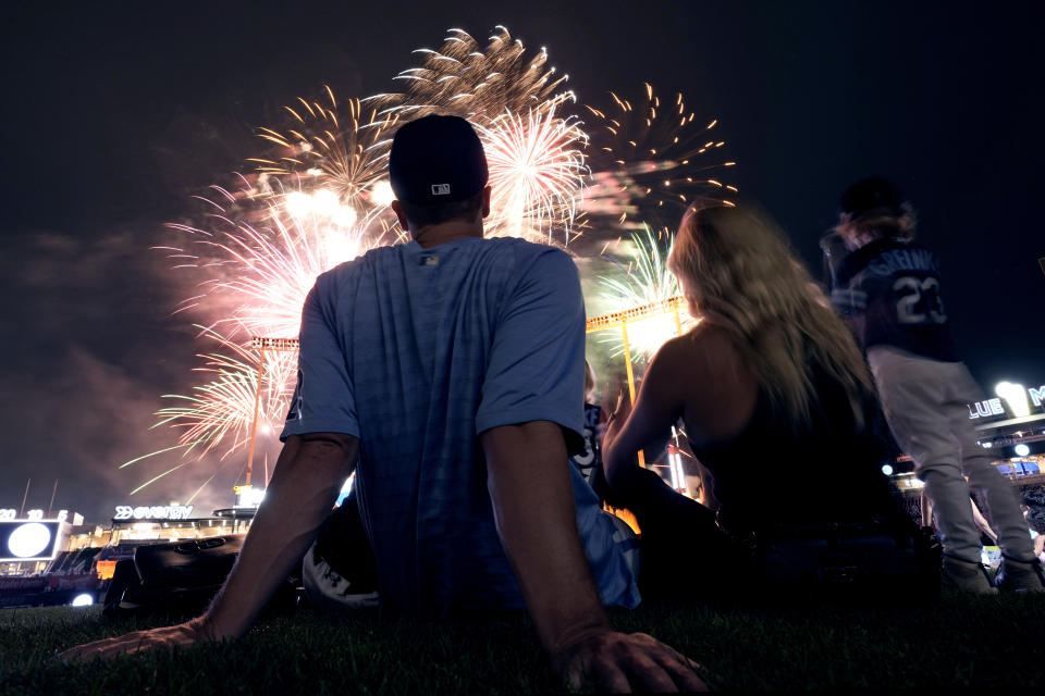 Kansas City Royals starting pitcher Zack Greinke and his family watch fireworks from the field after a baseball game.