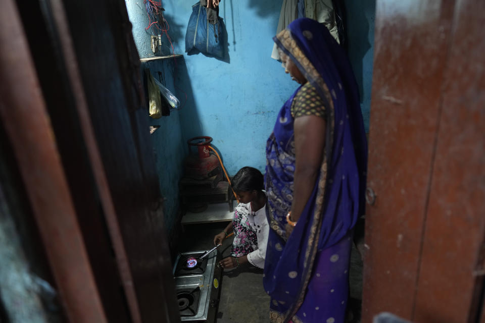 A girl lights a gas cylinder in her hut, received under a government scheme for the poor, in a shanty town on the outskirts of Patna, in the Indian state of Bihar, on May 11, 2024. (AP Photo/Manish Swarup)