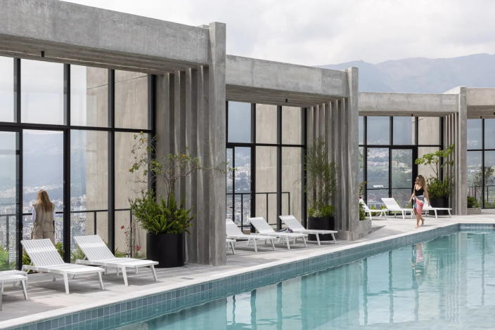 Los residentes disfrutan de la vista de la ciudad desde la lujosa piscina en la azotea del edificio IQON.