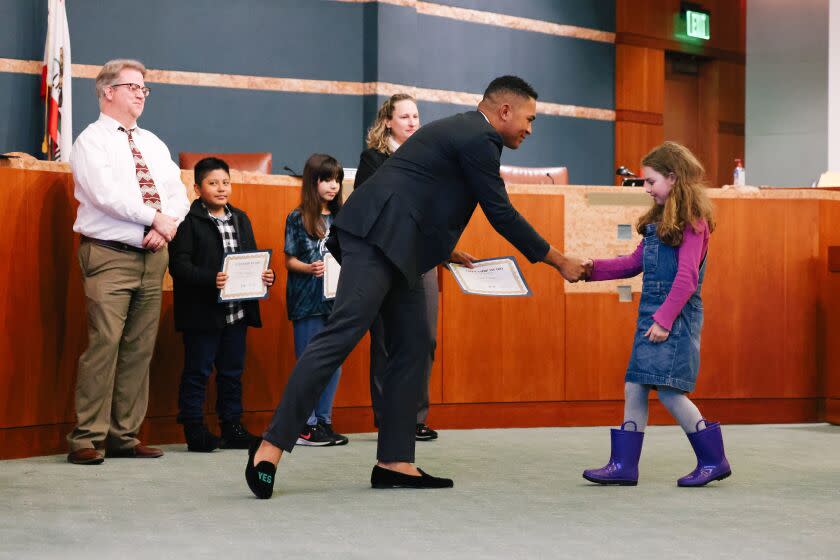 Los Angeles, CA - March 14: Triston Ezidore, 19, congratulates Talia Coleman on her Citizenship Award during a board meeting at the Culver City Hall on Tuesday, March 14, 2023 in Los Angeles, CA. The USC sophomore launched a campaign last summer to run for the Culver City Unified School District Board of Education and won. (Dania Maxwell / Los Angeles Times).