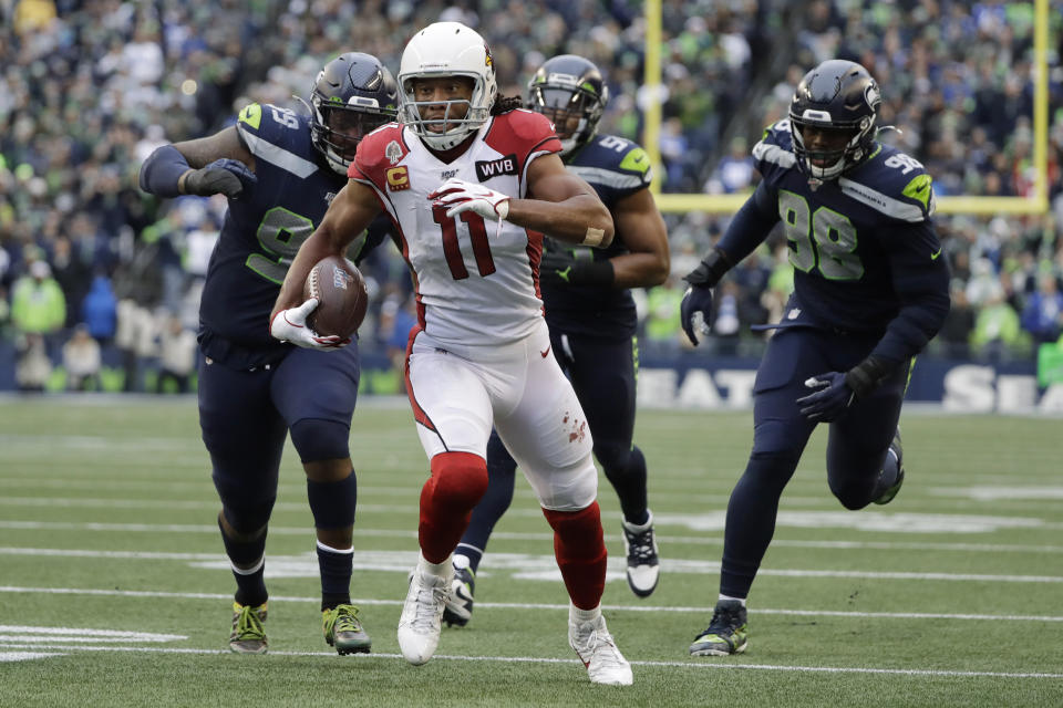 Arizona Cardinals wide receiver Larry Fitzgerald (11) runs for a touchdown after a reception as Seattle Seahawks defensive tackle Quinton Jefferson, left, and defensive end Rasheem Green, right, pursue during the first half of an NFL football game, Sunday, Dec. 22, 2019, in Seattle. (AP Photo/Elaine Thompson)