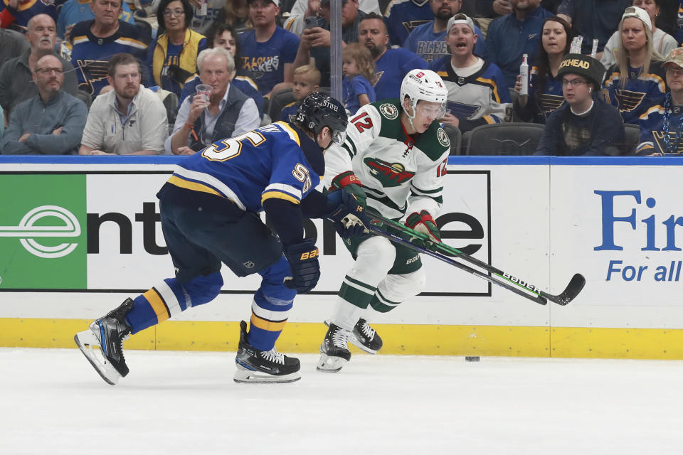 Minnesota Wild's Matt Boldy (12) works the puck against St. Louis Blues' Colton Parayko (55) during the first period in Game 6 of an NHL hockey Stanley Cup first-round playoff series Thursday, May 12, 2022, in St. Louis. (AP Photo/Michael Thomas)