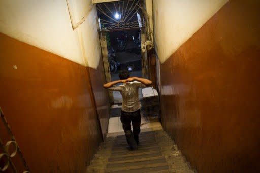 Pakistani sex worker, Nadeem who pimps 10 teenage sex workers aged 14-18, is seen walking down the stairs of a building in Karachi. According to charities which work to protect street children in Pakistan, up to 90 percent are sexually abused on the first night that they sleep rough and 60 percent accuse police of sexually abusing them