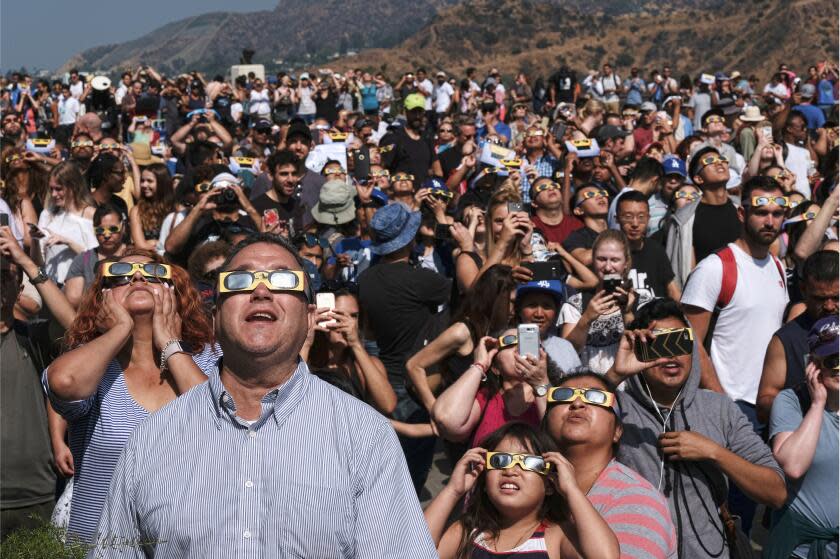 People wearing protective eye glasses watch the solar eclipse at the Griffith Observatory to watch the solar eclipse in Los Angeles Monday, Aug. 21, 2017. (AP Photo/Richard Vogel)