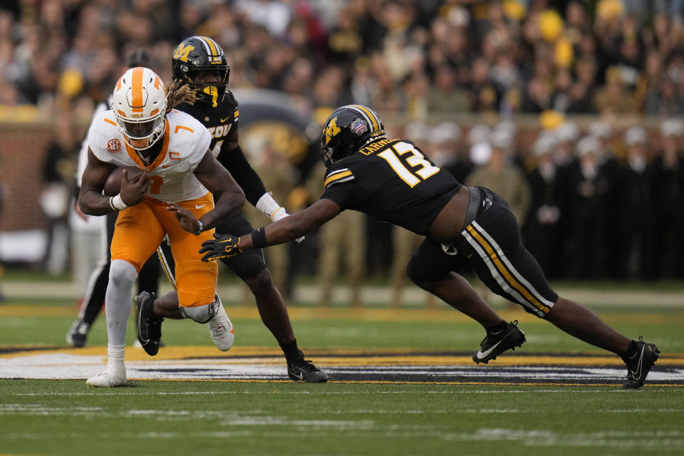 Tennessee quarterback Joe Milton III (7) runs with the ball as Missouri defensive back Daylan Carnell (13) defends during the first half of an NCAA college football game Saturday, Nov. 11, 2023, in Columbia, Mo. (AP Photo/Jeff Roberson)