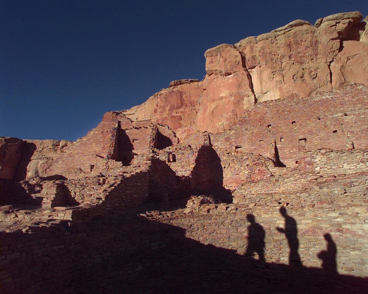 Tourists cast their shadows on the ancient Anasazi ruins of Chaco Canyon in N.M. in 1996. The UNESCO World Heritage Site has become a flash point as tribal leaders and environmentalists look to curb drilling.
