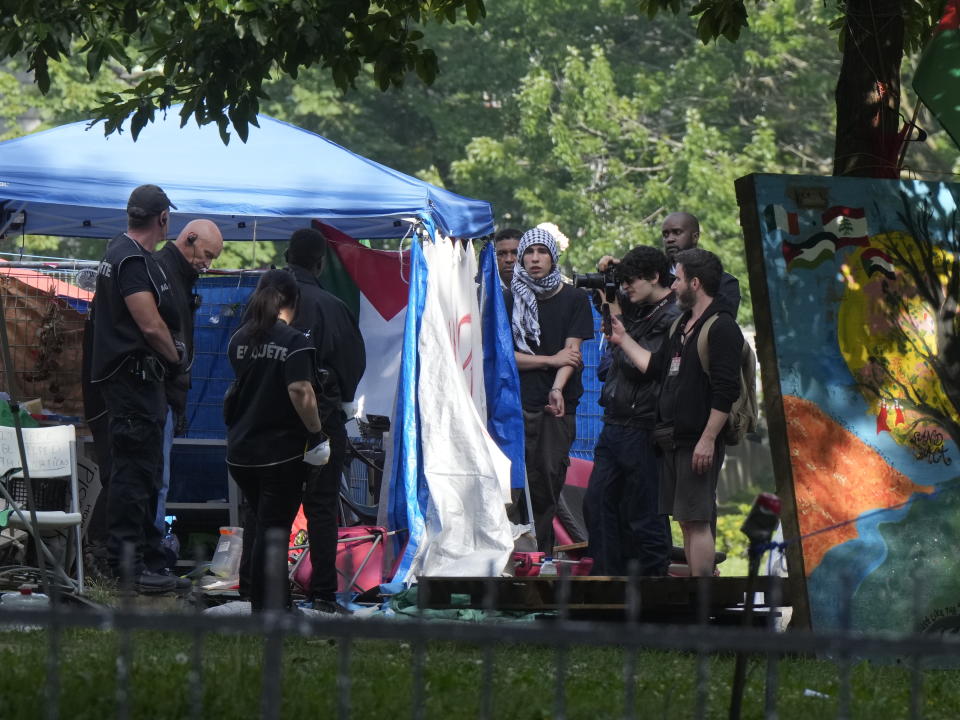 Security moves in on an encampment at McGill University in Montreal, Wednesday, July 10, 2024. The university closed its downtown campus as police descended in large numbers to help clear a pro-Palestinian encampment. (Ryan Remiorz/The Canadian Press via AP)