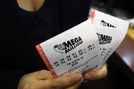 A customer holds Mega Millions tickets at a newsstand in midtown Manhattan in New York, U.S., October 19, 2018. REUTERS/Mike Sugar