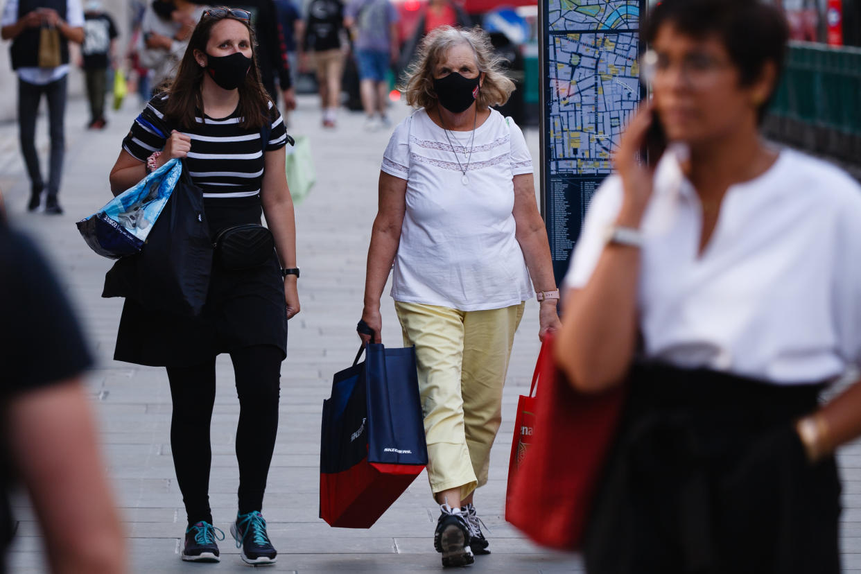 Women wearing face masks walk along Regent Street in London, England, on September 22, 2020. British Prime Minister Boris Johnson this afternoon announced a raft of new coronavirus restrictions to apply across England, possibly to last the next six months, including requiring pubs and restaurants to close at 10pm and for retail staff to all wear face masks. A return to home working where possible is also being encouraged. The new measures come amid fears of a 'second wave' of covid-19 deaths prompted by rising numbers of people testing positive in recent weeks. (Photo by David Cliff/NurPhoto via Getty Images)