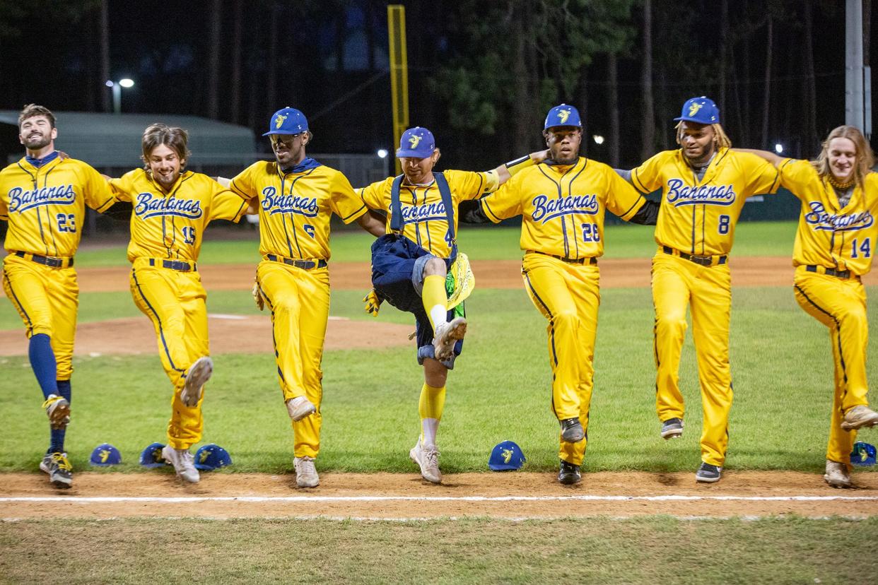 Pitcher/infielder Mat Wolf (4, in blue suspenders and baggy pants), dances in a kick line with teammates on the Savannah Bananas Premier Team before a game against the Party Animals on March 12 at Grayson Stadium.